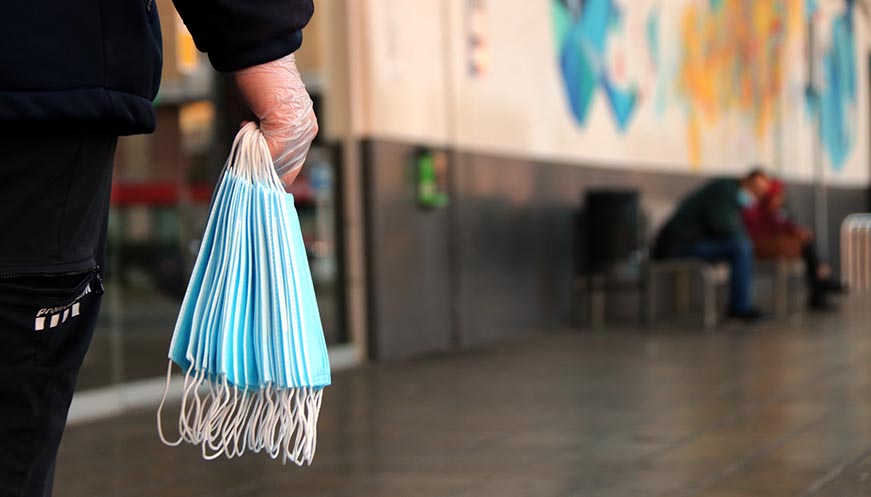 Voluntaris de Creu Roja i de Protecció Civil reparteixen mascaretes des de primera hora del matí al transport públic